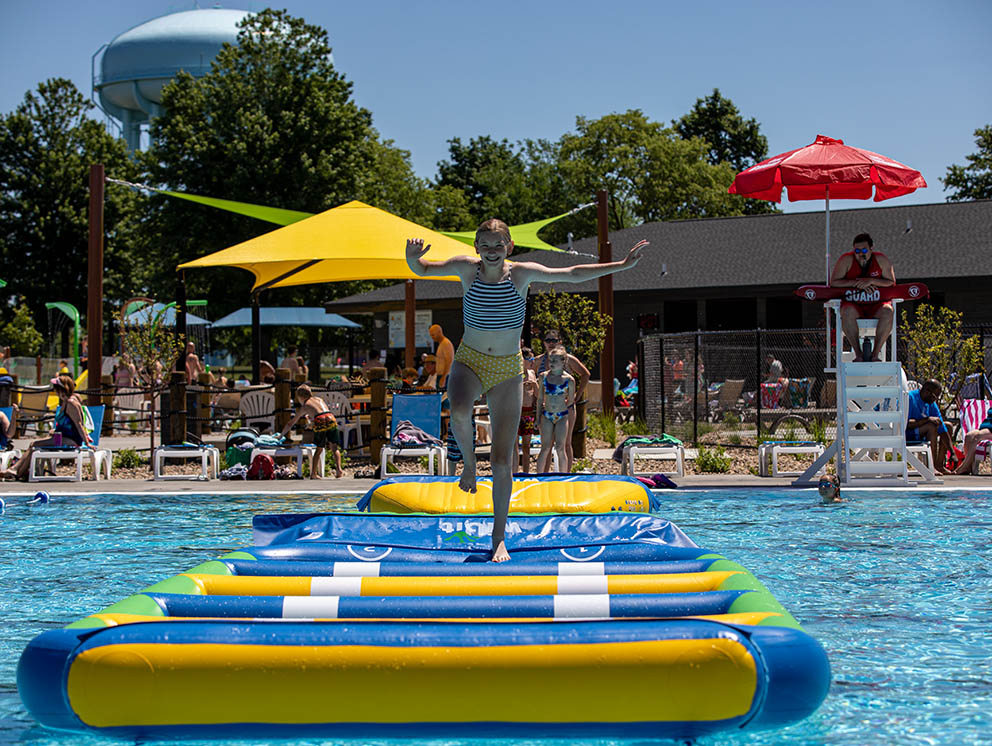 Boy splashing in pool.